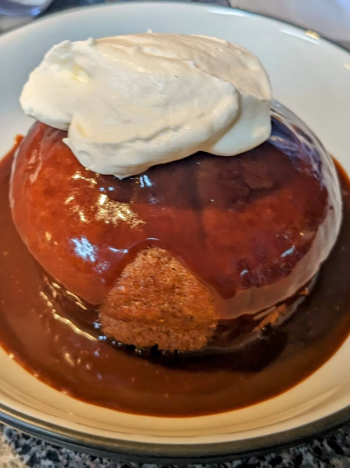 figgy pudding with sauce and whipped cream in a bowl